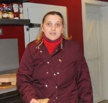 Mirella, en veste bordeaux, au comptoir